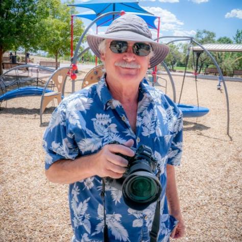 Man with camera posing for photo. 