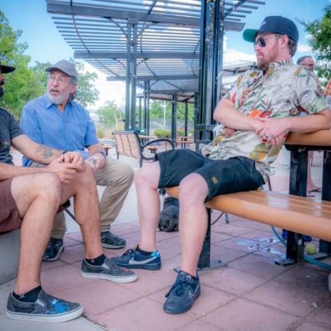 Three men sitting and talking. 