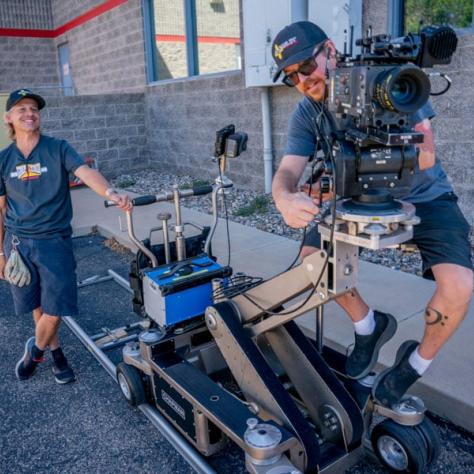 People working behind large camera. 