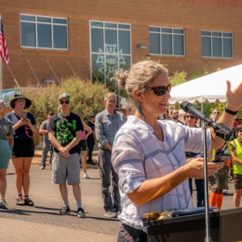 Woman speaking at podium outside. 