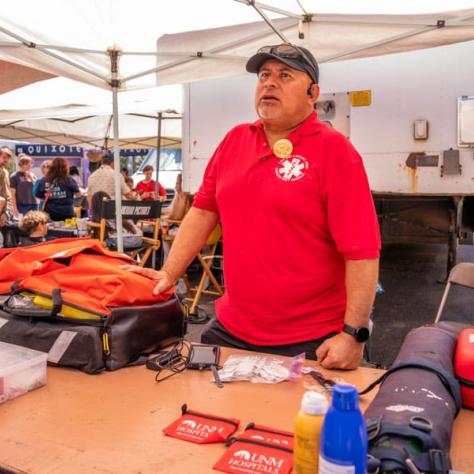 Man with red shirt at tent outside. 