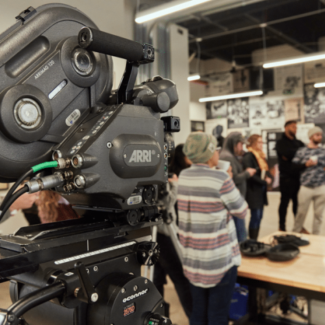 Camera and view of people watching something. 