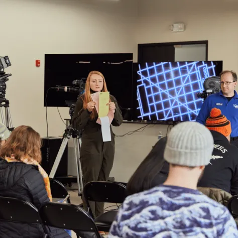 People presenting at the front of the room. 