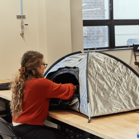 Woman working with mini tent on table. 