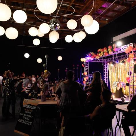 View of dark room with performer on stage. 