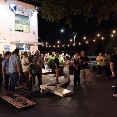 People at a party and playing cornhole. 