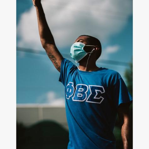 Man in blue shirt holding fist in the air. 