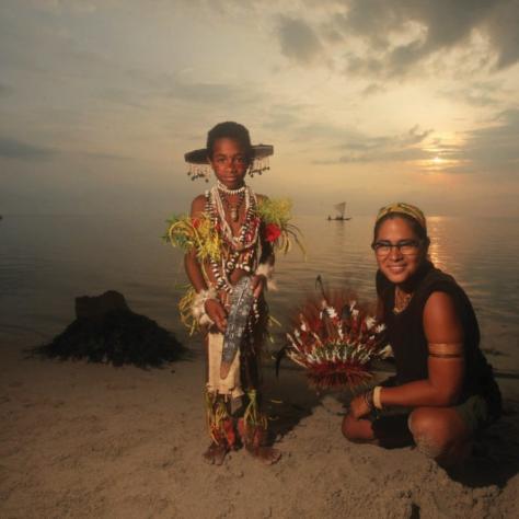 People dressed in village garb on beach at dusk. 