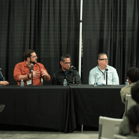 People sitting at a table with mics. 