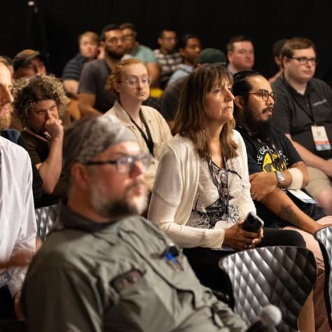 Audience members watching something. 