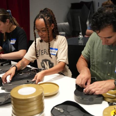 People at a table working with film. 