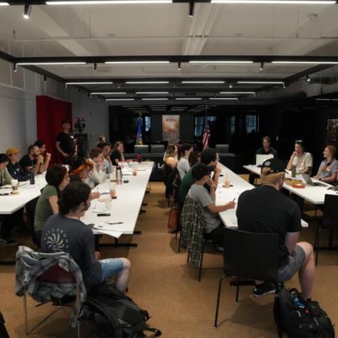 People sitting at long tables. 