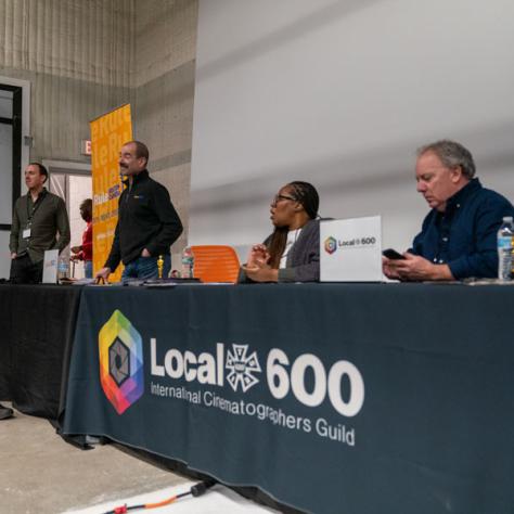 Panel of people behind a desk. 