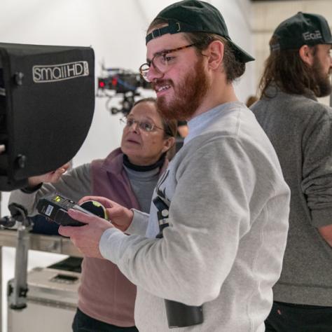 Person working behind a camera.