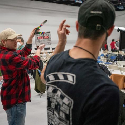 Candid photo of person with clapperboard. 