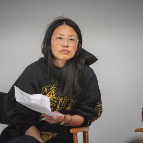 Woman sitting in a chair with paper. 