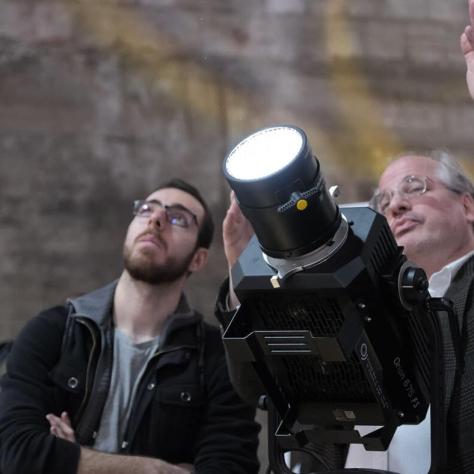 Two men pointing light up. 