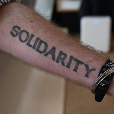 Arm with 'SOLIDARITY' written on it. 