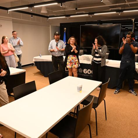 People standing around table. 