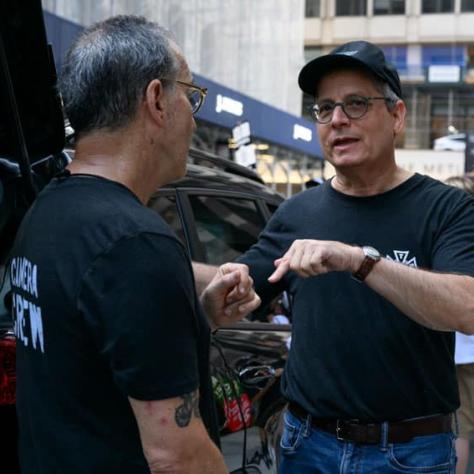 Two men talking to each other outside. 