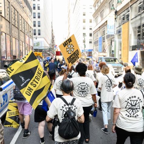 Back of people marching with signs. 