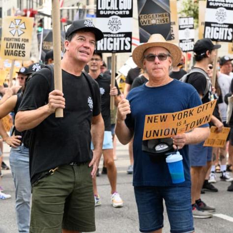 People posing for photo with signs. 