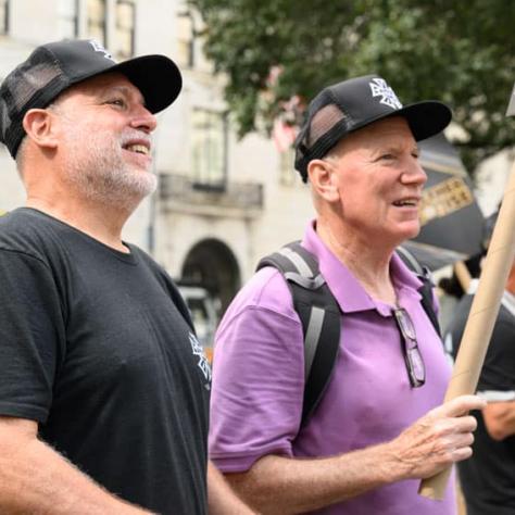 Two men marching with signs. 