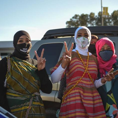 People posing for photo with peace sign. 