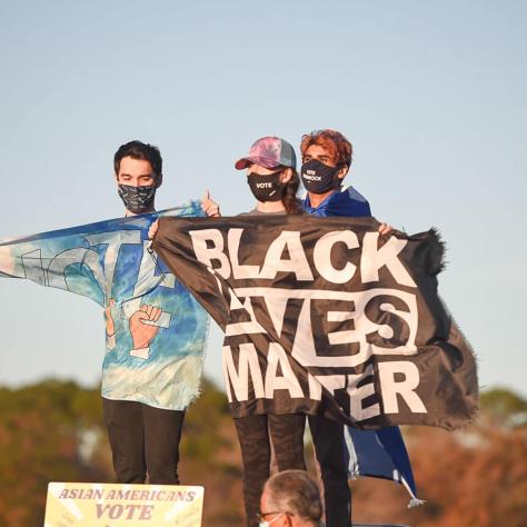 People posing with Black Lives Matter flag. 