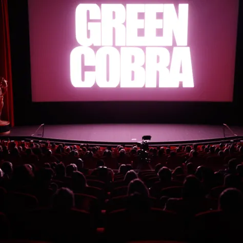 Audience and stage with Green Cobra on screen. 