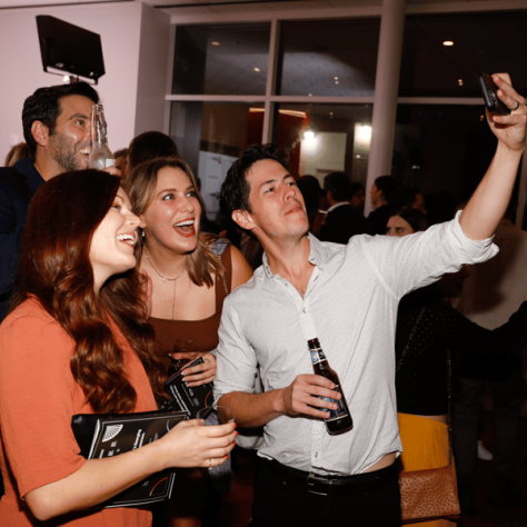 People taking selfies at a party. 