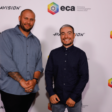 Men posing for photo with backdrop. 