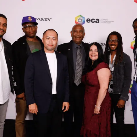 Group of people posing for photo in front of backdrop.