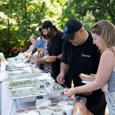 People getting food at buffet table. 