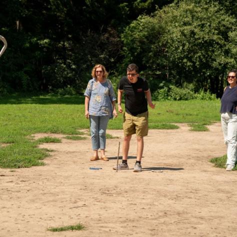 People throwing horse shoes. 