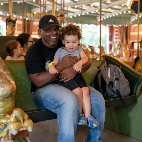 Man and child on carousel. 