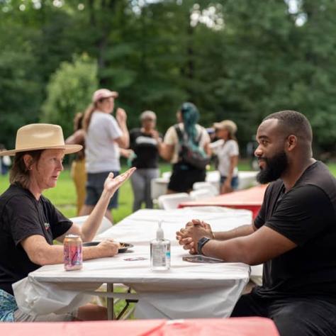 Two people sitting at a table talking. 