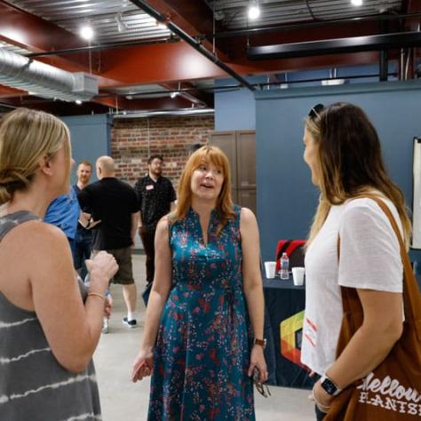 Three women standing and talking. 