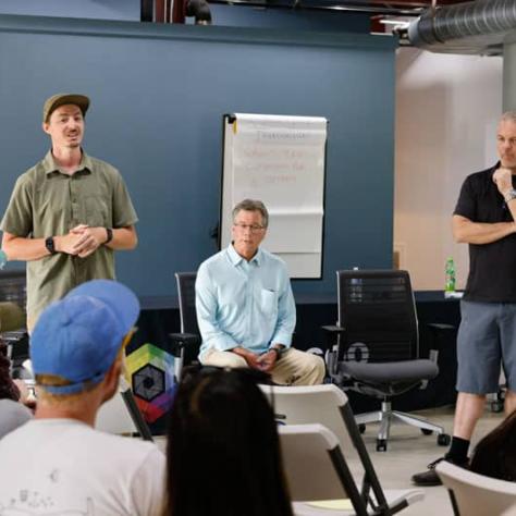 Men standing in front of audience.