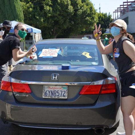 People drawing on car windows.