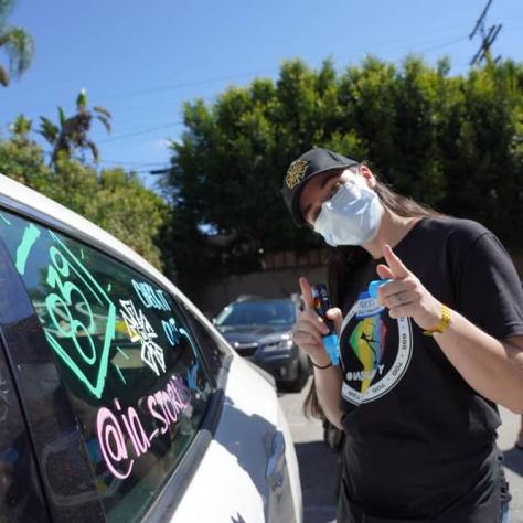 Person posing for photo next to car. 