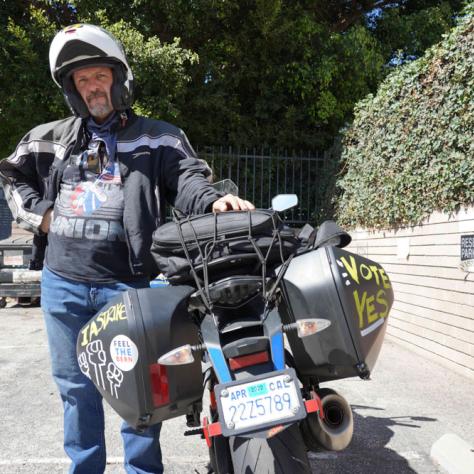 Man posing with a motorcycle. 