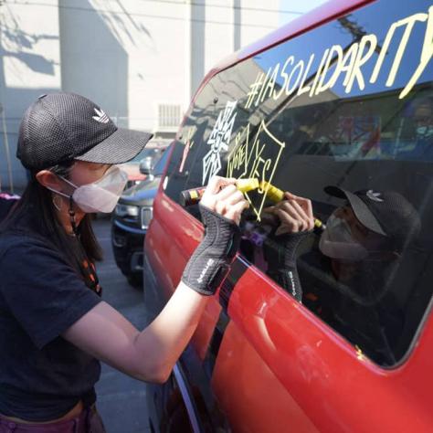 Person drawing on a car window. 