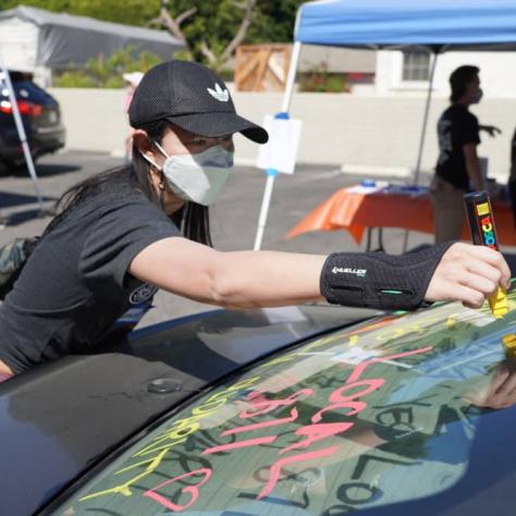 Person drawing on a car window. 