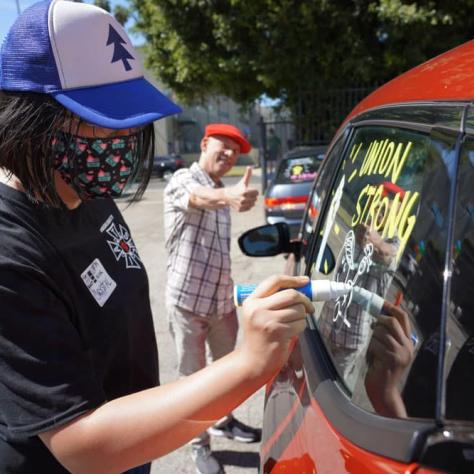 Person drawing on a car window. 