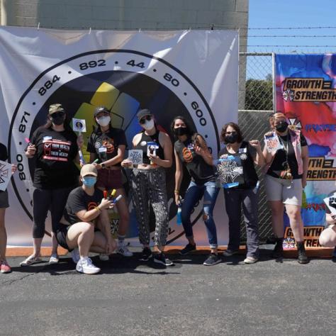 Group of people posing for a photo in front of a backdrop. 