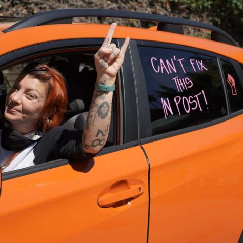 Woman posing with hand out the window of car. 