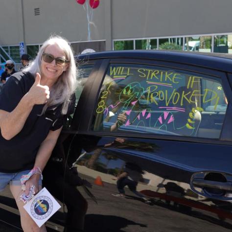 Woman posing with decorated car window. 