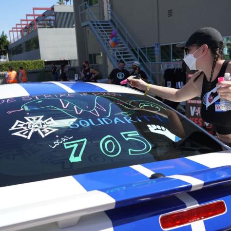 Person drawing on a car window. 