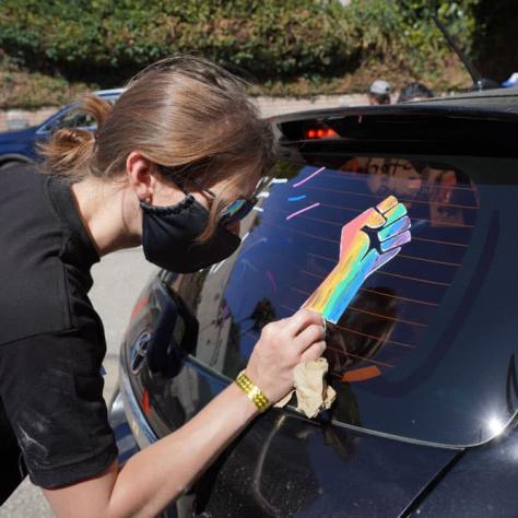 Person drawing on a car window. 